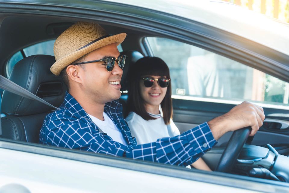 Pareja sonriendo dentro de un auto