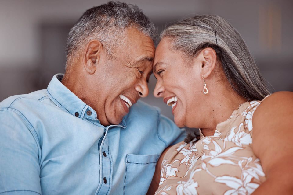 Pareja de adultos mayores riendo junta en casa